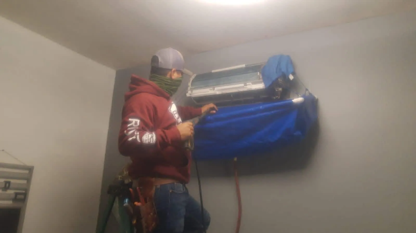 Técnico realizando lavado a presión y mantenimiento de minisplit